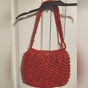 Red strawberry colored straw shoulder bag.